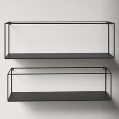 two black shelves against a white wall, one is empty and the other has no shelf