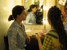 two women sitting at a table in front of a mirror