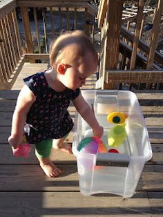 a toddler playing with toys on a deck