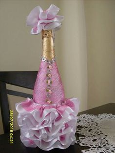 a pink and white dress sitting on top of a table next to a wine bottle