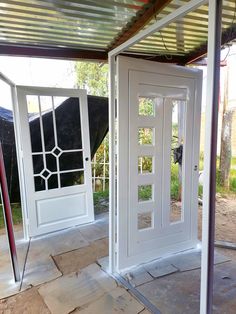 two white doors are open in an outdoor area