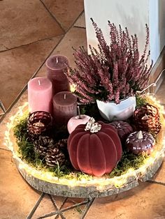 some candles are sitting in a bowl on the floor