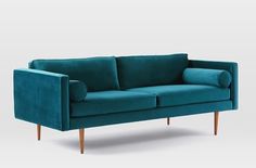 a teal colored couch with wooden legs and arm rests on an isolated white background