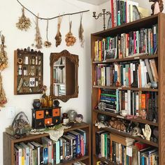 a bookshelf filled with lots of books next to a mirror and other items