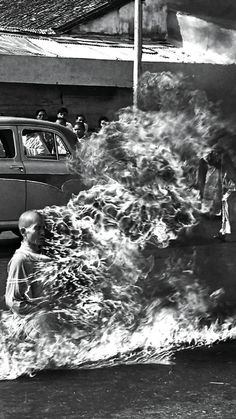 an old black and white photo of people standing around a fire hydrant with flames coming out of it