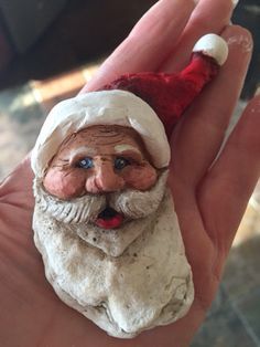 a small santa clause figurine in someone's hand