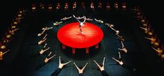 a group of people standing on top of a stage holding hands in the shape of a circle