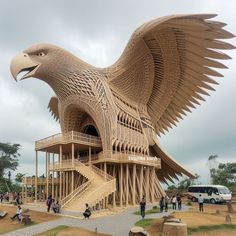 a large wooden eagle sculpture sitting on top of a lush green field