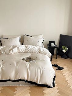 a white bed with black trim and pillows