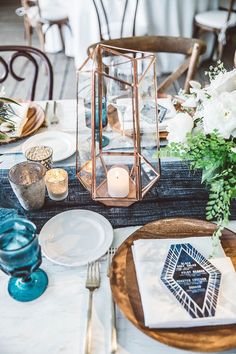 a table setting with candles, plates and napkins