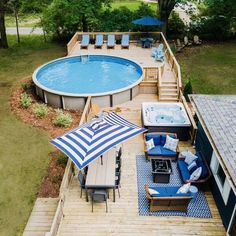an above ground pool with lounge chairs and umbrellas next to the decking area