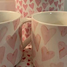 two coffee mugs with hearts painted on them