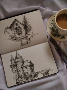 there is a cup of coffee next to a notebook with a drawing on it and a pen