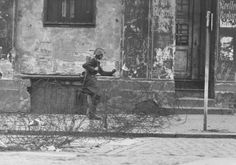 black and white photograph of two people sitting on a bench in front of an old building