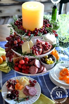 a table topped with plates filled with food and a lit candle on top of it