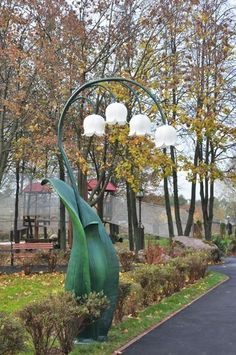 a large green sculpture in the middle of a park