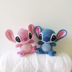 two crocheted stuffed animals sitting on top of a ball of yarn next to each other