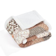 three blankets stacked on top of each other in different colors and patterns, one with a white blanket