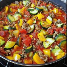 a pan filled with meat and vegetables on top of a stove