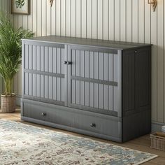 a gray cabinet sitting next to a rug on top of a wooden floor