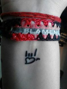 a person wearing a red and black bracelet with the word pinterest on it