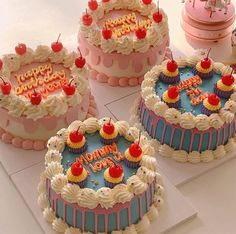 three birthday cakes with cherries on them sitting on top of a white countertop