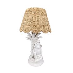 a table lamp with a white base and a woven shade on the top of it