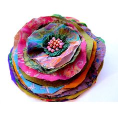 a stack of fabric flowers sitting on top of each other in front of a white background
