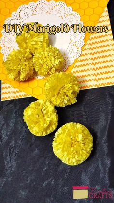 three yellow flowers sitting on top of a piece of paper next to a doily