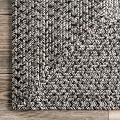 an area rug with grey and white herringies on the wood floor, top view