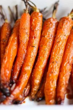 some carrots are sitting on a white plate and have been seasoned with seasoning