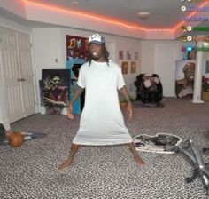 a man standing in the middle of a living room wearing a white t - shirt dress