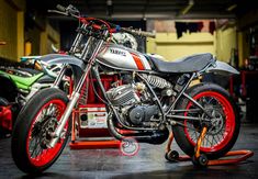 an orange and black motorcycle parked in a garage