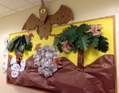 a bulletin board with paper flowers and bats on it