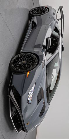 the top view of a grey sports car with wheels on it's roof is shown from above