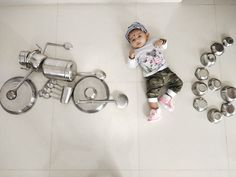 a baby is laying on the floor next to some silver objects