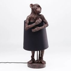 a monkey lamp with a black shade on it's head and arms wrapped around the base