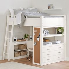 a white loft bed with a desk underneath it and shelves below the bed for storage