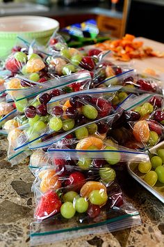 grapes and oranges are wrapped in plastic bags