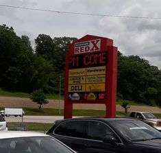 a parking lot with cars parked in front of it and a red sign that says pit come