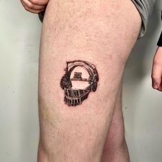 a man's leg with a small circle tattoo on the side of his thigh