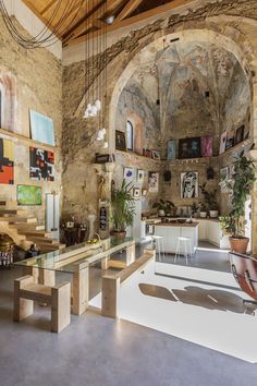 the interior of an old building with art on the walls and tables in front of it