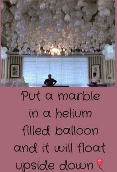 a man sitting in a room with balloons on the ceiling and a quote written below