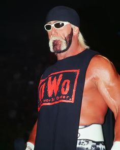 an old man wearing sunglasses and a shirt with the word oww on it is standing in front of a crowd