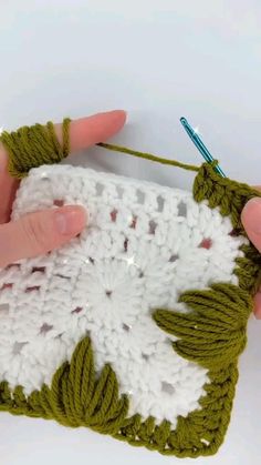 someone crocheting an object with green yarn