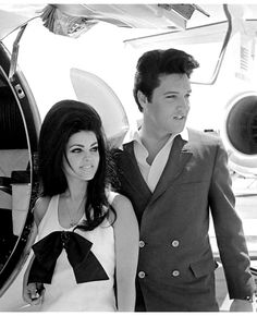 a man and woman standing in front of an airplane