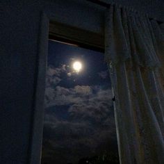 the full moon is seen through an open window