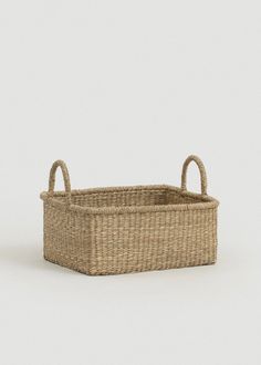 a small basket with handles on the side and one handle in the middle, against a white background