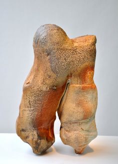 two clay sculptures sitting on top of a white table