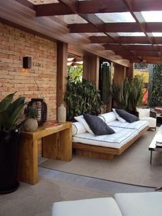 an outdoor living area with couches, tables and potted plants